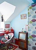 Retro style television and chair at desk below dormer window in County Durham home, North East England, UK