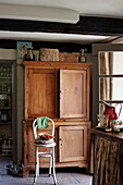 Chair and wooden cabinet at open back door of Powys cottage, Wales, UK