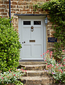 Eingangstür mit Stufen aus Stein eines Landhauses in Oxfordshire, England, UK