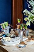 Budding crocus with plates and bread on kitchen table in Chippenham home, Wiltshire, UK