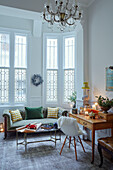 Desk and chair with sofa in leaded glass bay window of East Grinstead home, West Sussex, UK