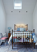 Lichtspiele auf einem Bett mit Metallkopfteil und Patchworkdecke in einem Haus in Worcestershire, England, UK