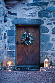 Lit lanterns at old wooden front door of Scottish castle, UK