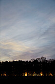 Sunset behind woodland at dusk in Northumberland, UK