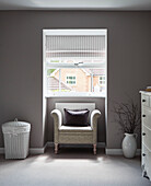 Laundry basket and window seat in muted North Yorkshire bedroom, UK