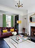 Red leather sofa and glass coffee table with green and yellow accents in Durham home, England, UK
