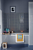 Grey tiled bathroom withlit tealights in Brittany cottage, France