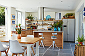 Open plan kitchen with flagstone flooring table and chairs in Bath home, Wiltshire, UK