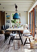 Large blue pendant shade hangs over wooden table in Devon home, UK