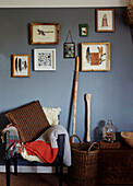 Gerahmte Objekte an blauer Wand mit Stuhl in einem Haus in Gladestry an der Grenze zu Südwales