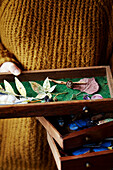 Woman holding drawer of handmade paper leaves in Gladestry studio on South Wales borders