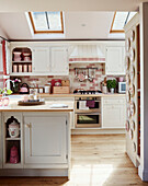 White fitted kitchen with skylight windows in Cotswolds cottage, UK