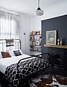 Gardinen und Bett mit Metallrahmen und Bücherregal in einem Haus in Ramsgate, Kent, UK