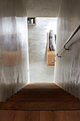 Steile Holztreppe und polierte Betonwände mit Handlauf in einem Haus in Sligo, Irland