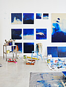 Art equipment and wall mounted canvases of waves breaking in Sligo studio Ireland