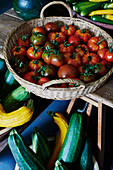 Basket of tomatoes and harvested courgettes at Old Lands kitchen garden Monmouthshire, UK