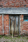 Gartengeräte an gemauertem Schuppen im Küchengarten von Old Lands, Monmouthshire, UK