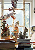 Gartenzwerg und Figuren mit Büchern auf der Fensterbank in Somerset, UK