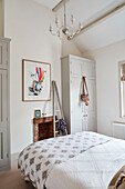 Gerahmter Druck und Kleiderschrank in einem hellen Schlafzimmer in Oxfordshire, UK