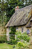 Garden exterior of thatched Oxfordshire cottage, UK