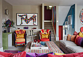 Bright fabrics and artwork in living room of London apartment, UK