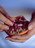 Hands holding pomegranate fruit