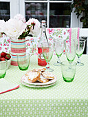 Geschirr und Besteck auf einem Gartentisch an einem Sommertag