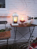 Cut flowers and lit lantern on table of Herefordshire garden exterior England, UK