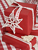 Handmade snowflakes on red gift wrapped Christmas presents in Polish home