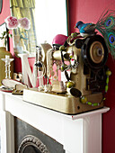 Vintage jewellery on sewing machine on fireplace in Winchester home, Hampshire, UK