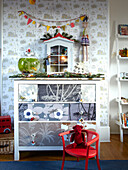 Wallpapered chest of drawers in child's room of family home, France