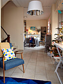 Blue vintage chair and Christmas tree in open plan living room of family home, France