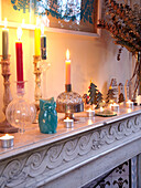 Brennende Kerzen auf einem Marmorkamin in einem Einfamilienhaus in Frankreich