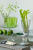Still life with glass cake stand forks limes flowers and celery