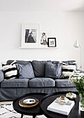 Grey sofa with cushions and black nest of coffee tables in Reigate living room, Surrey, UK
