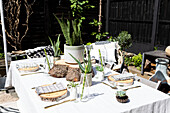 Baumstammscheiben als Platzsets mit Bronzebesteck auf einem Tisch im Garten von Colchester in Essex UK