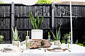 Baumstammscheiben als Platzdeckchen mit Bronzebesteck und Sukkulenten auf dem Tisch im Garten von Colchester, Essex UK