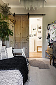 Schiebetür aus Altholz mit Tagesbett und Kleiderstange in einem Haus in Colchester, Essex, UK