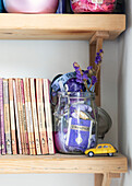 Toy car and paperback books with glass jar and colour grouping Brighton, East Sussex UK