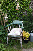 Alter Holzstuhl mit rostigen Metalllaternen im Garten in Brighton, East Sussex UK