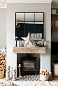 Nahaufnahme eines Kamins mit Holzofen und Kerzen im Scandi-Stil in einem Wohnzimmer mit rustikalem Touch in Cardiff Wales UK