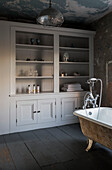 Large storage cabinet and freestanding bath with industrial pendant in Somerset home UK