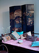 Oriental room set with Chinese painted screen and Chinese daybed with scatter cushions in blue pink and brown