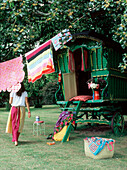 Old decorated green gypsy caravan in a garden