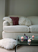 White comfy sofa in white living room with glass coffee table