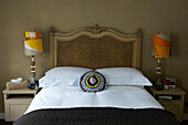 Crotched cushion on bed with symmetrical retro lamps