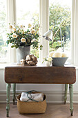 Cut flowers on wooden table at window of Canterbury home England UK