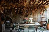 Dried flowers and salvaged furniture in garden room of Iden farmhouse, Rye, East Sussex, UK