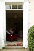 Dog sleeping in open doorway to Suffolk home, England, UK