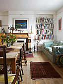 Bookcase and sofa in dining room of Aldeburgh home Suffolk England UK